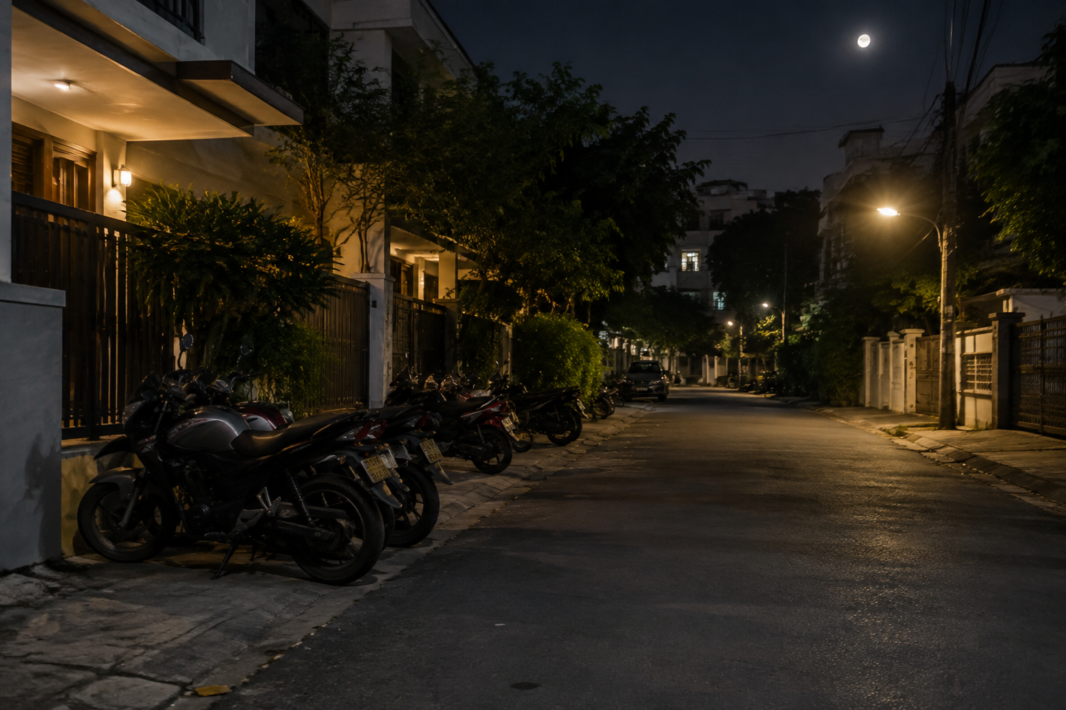 Calle residencial de noche con motos estacionadas